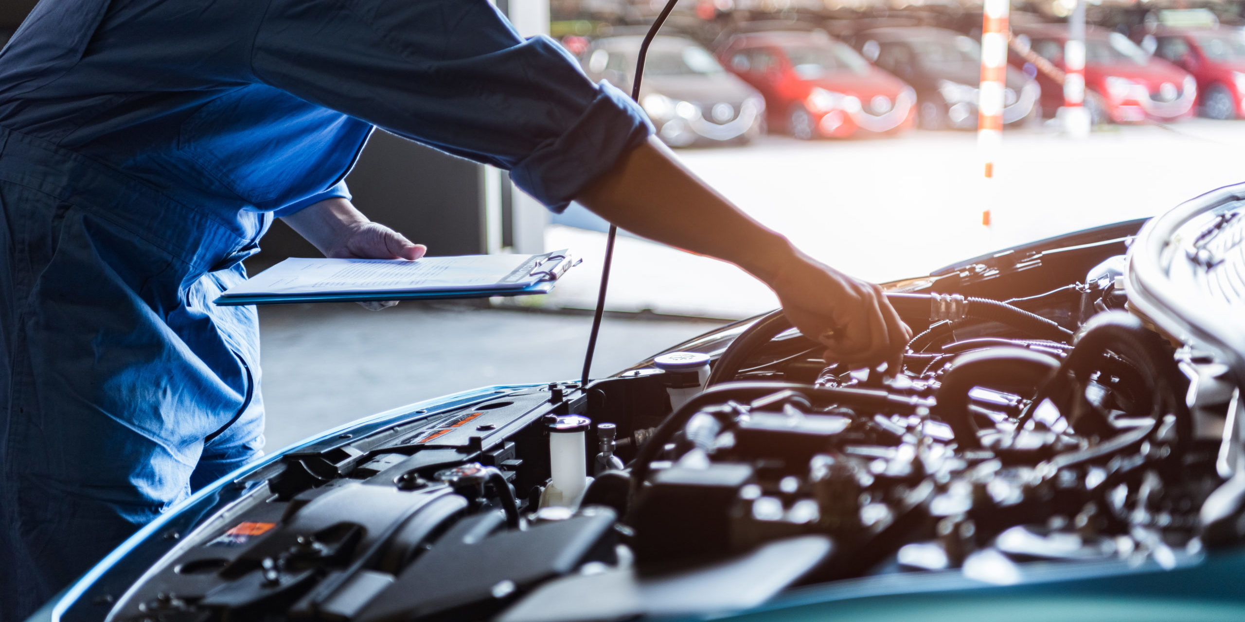 Car mechanic holding clipboard and checking to maintenance vehicle by customer claim order in auto repair shop garage. Engine repair service. People occupation and business job. Automobile technician