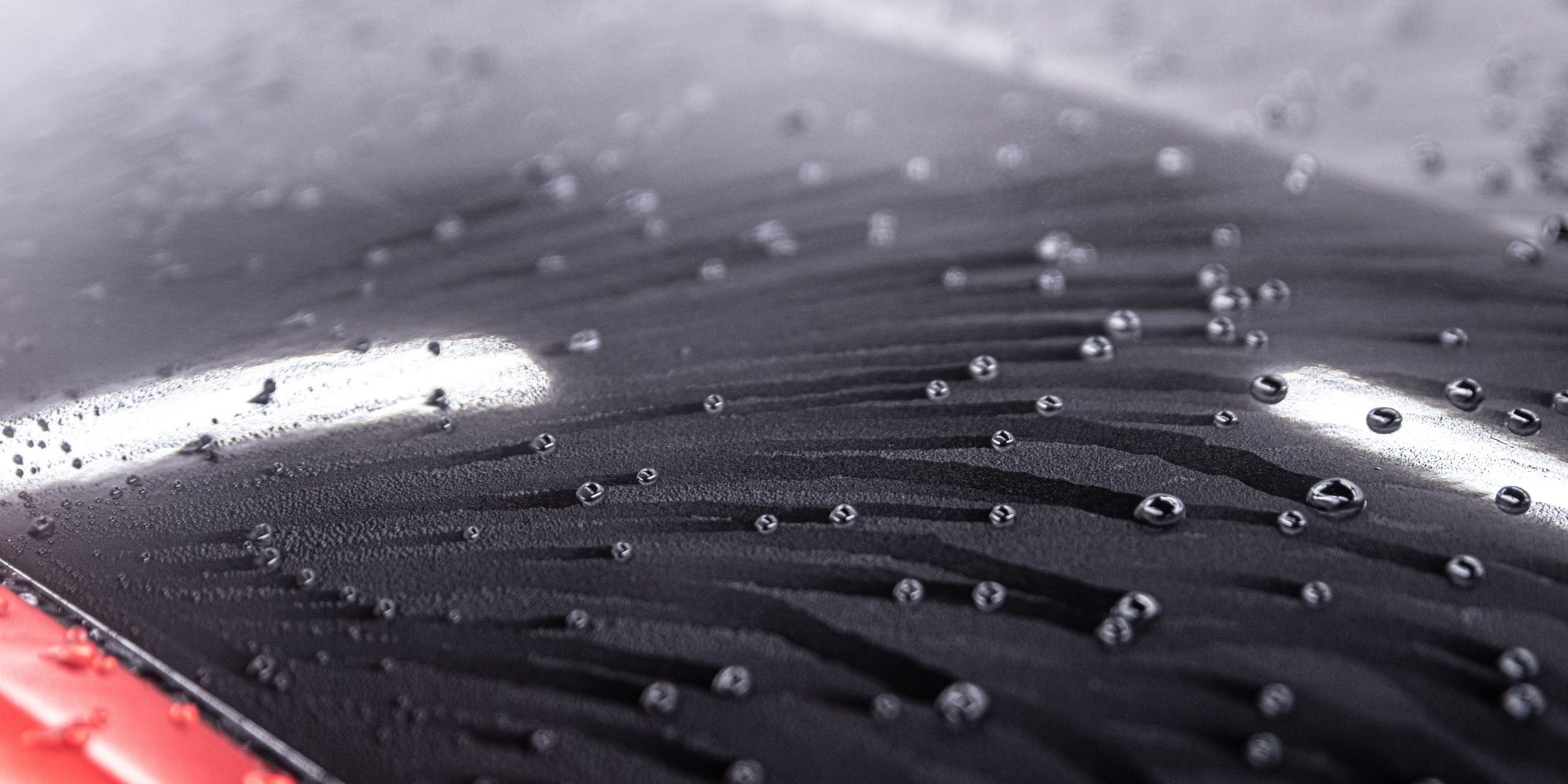 Water drops on car paint. Hydrophobic water effect on car body after using ceramic coating